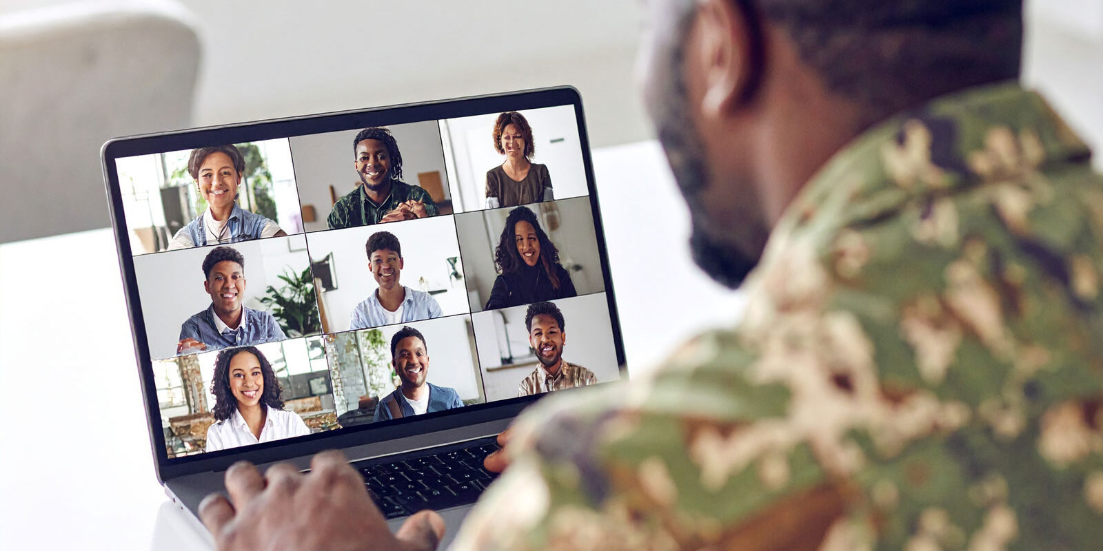 man-on-military-uniform-looking-at-a-laptop-screen-that-shows-a-grid
